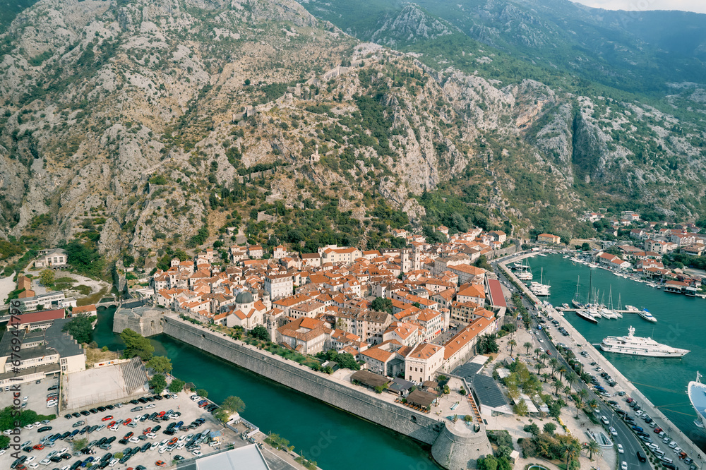 Fortress walls of the ancient town of Kotor on the shore of the bay. Montenegro. Drone