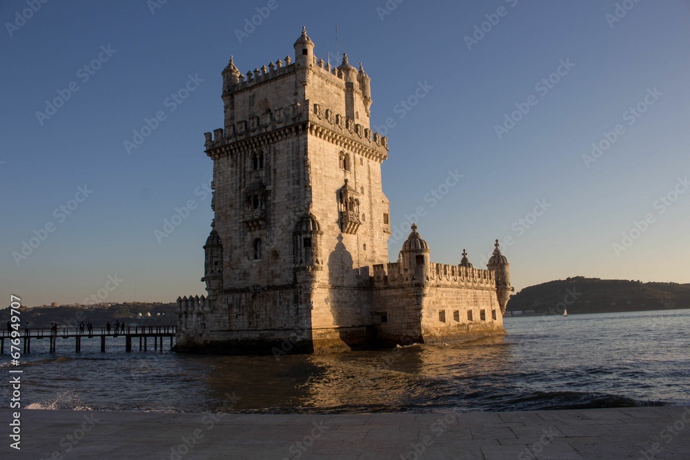Belem Tower surrounded by hills and water on a sunny day in Lisbon, Portugal