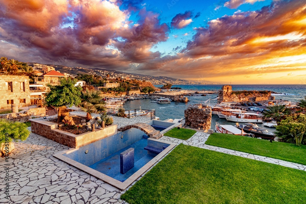 Swimming pool by the beach and the cityscape at sunset