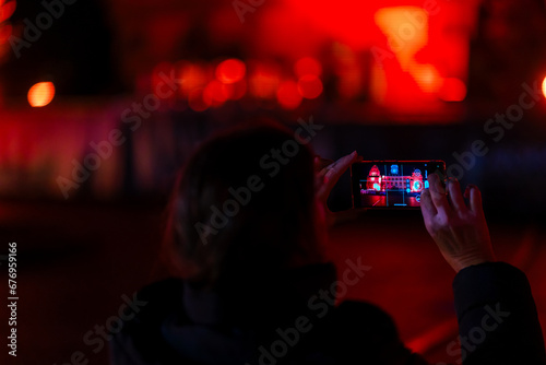 Hände halten ein Mobiltelefon bei einer Nachtaufnahme photo