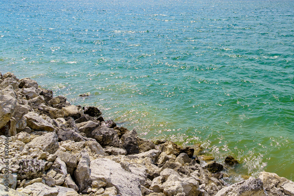 Rocky shore of a fresh reservoir. Background with selective focus and copy space Rocky shore of a fresh reservoir. Background with selective focus and copy space