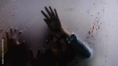 Out-of-focus infected zombie hands claw at bloodied window, signaling apocalypse. Haunting video, encapsulating dread and chaos of apocalypse. Concept terror of apocalypse looms, undead scratch glass