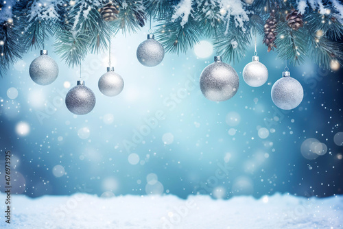Festive Christmas winter snow scene with silver baubles hanging from a Christmas tree out of focus background of lights and snow Christmas greeting card image wallpaper