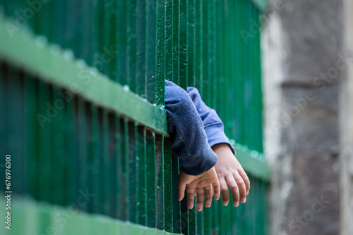 Obraz na plátne Child hands holding thick bars