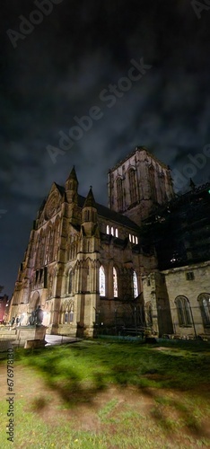 Vertical low angle view of Lincoln Cathedral with a cloudy dark sky in the background