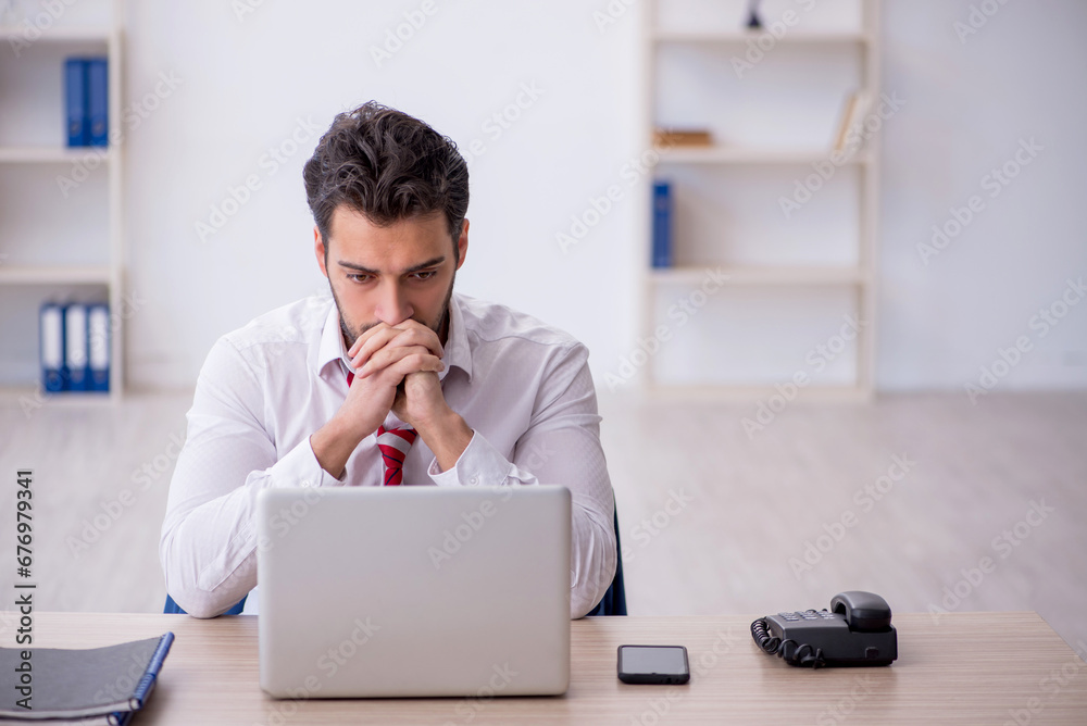 Young male employee working in the office Young male employee working in the office