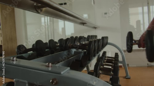 Female hands, bodybuilding, dumbbells in the gym. Closeup woman's hands taking weight lifting in sport club. Fitness girl having a sports workout in the fitness room. photo