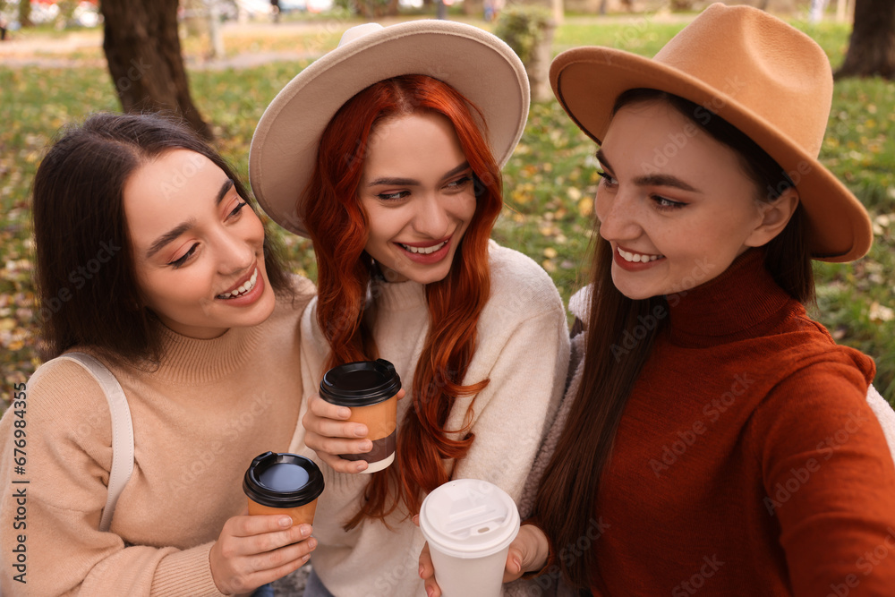 Happy friends with paper cups of coffee in park Happy friends with paper cups of coffee in park