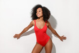 Beautiful woman in red one-piece summer swimsuit on white background