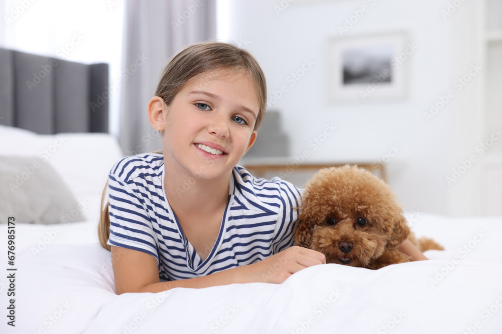 Little child and cute puppy on bed at home. Lovely pet Little child and cute puppy on bed at home. Lovely pet
