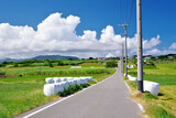 沖縄県小浜島 シュガーロードと青空と牧草ロール