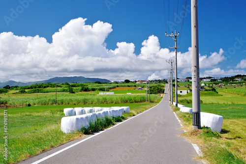 沖縄県小浜島　シュガーロードと青空と牧草ロール
