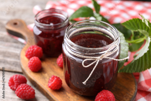 Delicious raspberry jam and fresh berries on table, closeup. Space for text