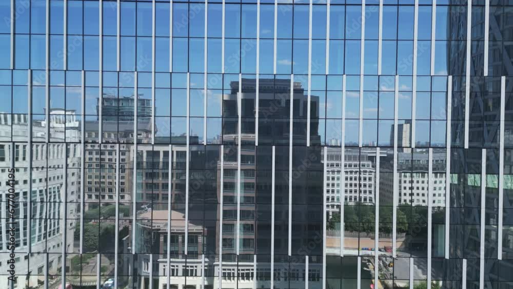 Bottom view of office building window close up, reflection and perspective. Modern architecture with sun ray. Glass facade on a bright sunny day with sunbeams on the blue sky.