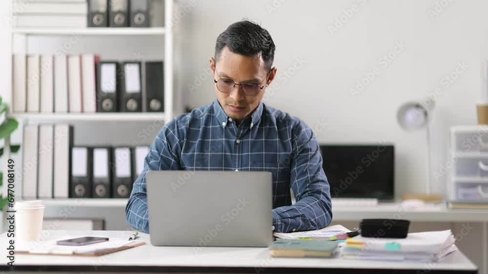 Businessman working on documents with laptop on table in office. Businessman working on documents with laptop on table in office.