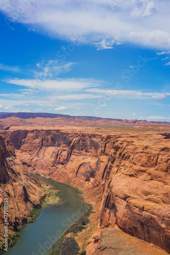 Scenic Vertical Shot of Horseshoe Bend canyon overlooking Colorado River in Page Arizona, USA. Bright Blue Sky.