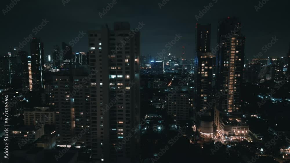 Beautiful aerial panorama of night Bangkok at nighttime. Camera moving up high between skyscrapers showing lights of the night city with modern buildings and streets, aerial drone shot of night city. Beautiful aerial panorama of night Bangkok at nighttime. Camera moving up high between skyscrapers showing lights of the night city with modern buildings and streets, aerial drone shot of night city.