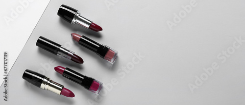 Set of different lipsticks on grey background with space for text