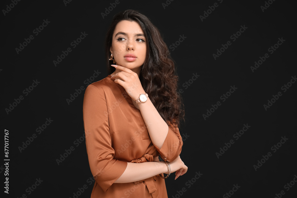Naklejka premium Elegant beautiful woman with wristwatch on black background