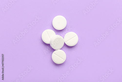 White medical pills on purple background