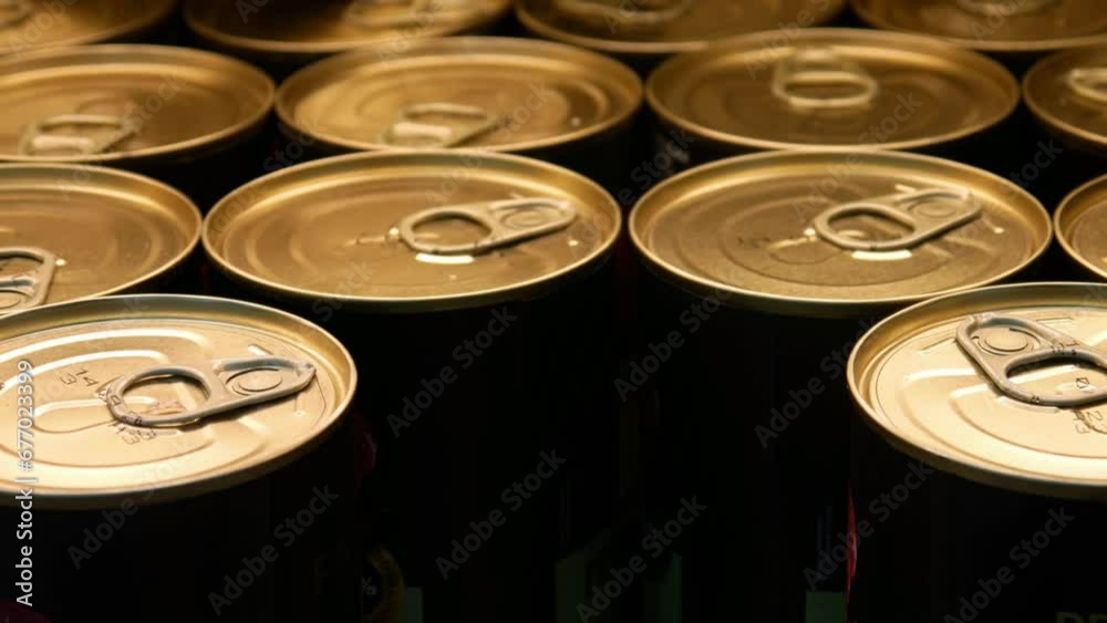 Close-up of many golden-black tins of canned food and a male hand takes one Close-up of many golden-black tins of canned food and a male hand takes one