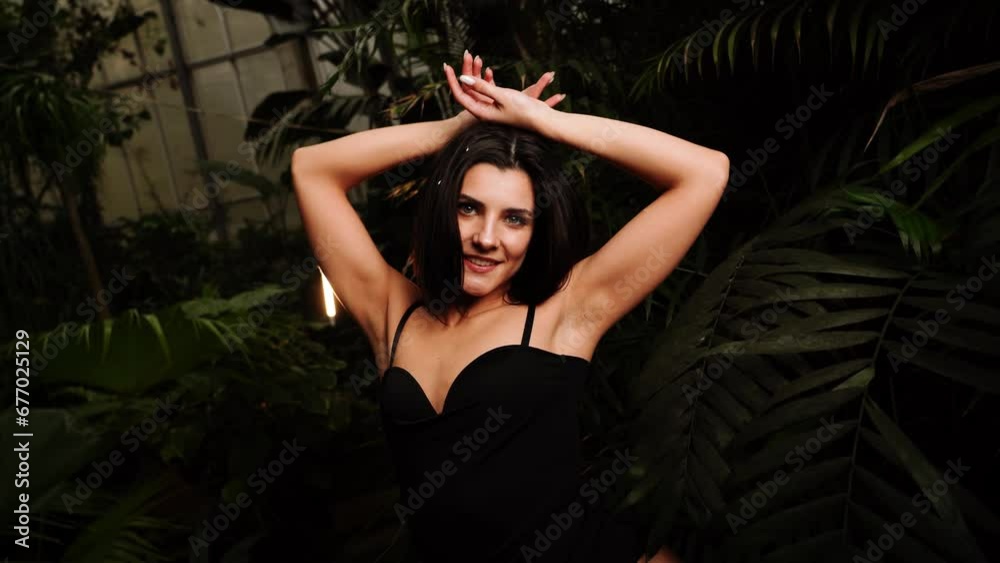 Sexy woman in a black bodysuit posing in a tropical garden. Concept of fashion photography. 4k Sexy woman in a black bodysuit posing in a tropical garden. Concept of fashion photography. 4k