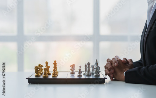 young businessman Asian man sitting holding hands looking at a chess set Business strategy concepts, business plans, teamwork Success management or leadership concept.