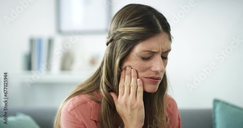 Woman, toothache and pain on living room sofa in oral, gum or mouth injury emergency at home. Face of sick female person with sore teeth, jaw or cavity and gingivitis problem on lounge couch at house photo