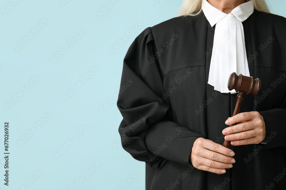 Female judge with gavel on blue background