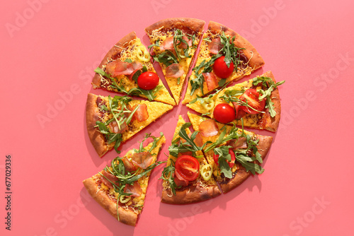 Pieces of delicious pizza with tomatoes and arugula on red background