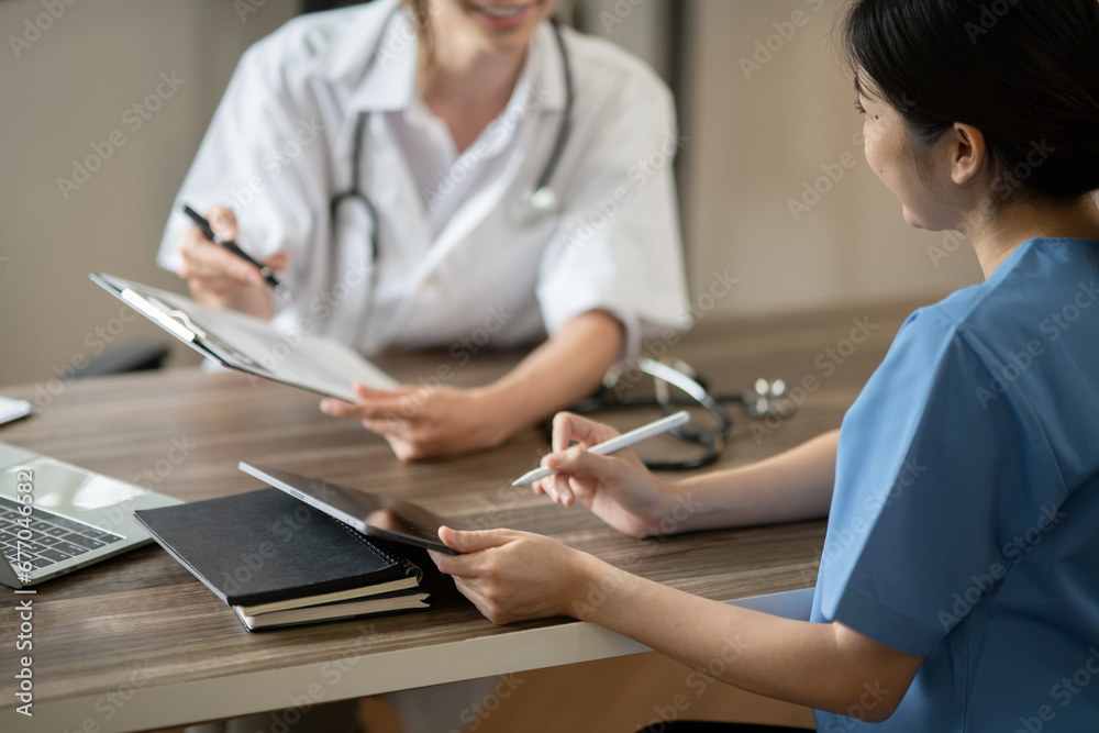 Obraz premium Female doctor sitting at work looking at the history of patients in the clinic or in the hospital