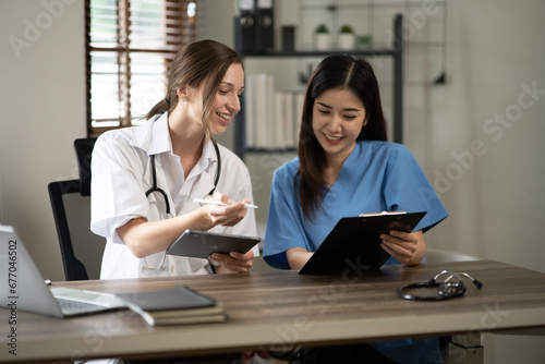 Female doctor sitting at work looking at the history of patients in the clinic or in the hospital