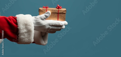 Santas Hand Grasping Christmas Present Clutching Wrapped Gift Spreading Joy and Wonder photo
