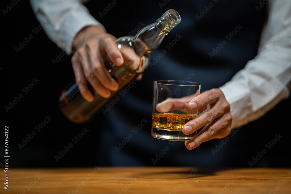 Bartender pours whiskey to customer in tavern Bartender pours whiskey to customer in tavern