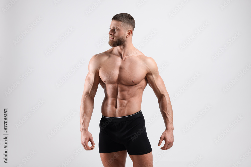 Young man is stylish black underwear on light grey background