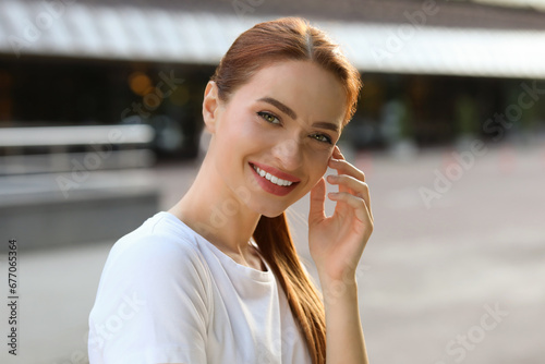 Portrait of happy young woman in casual clothes outdoors. Attractive lady smiling and looking into camera © New Africa