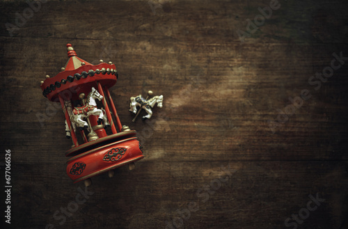 Antique toy carousel with horses. A vintage wooden toy is lying on the table. A clockwork musical carousel. photo