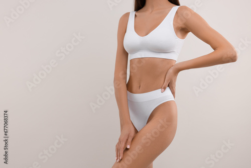 Young woman in stylish bikini on white background, closeup. Space for text