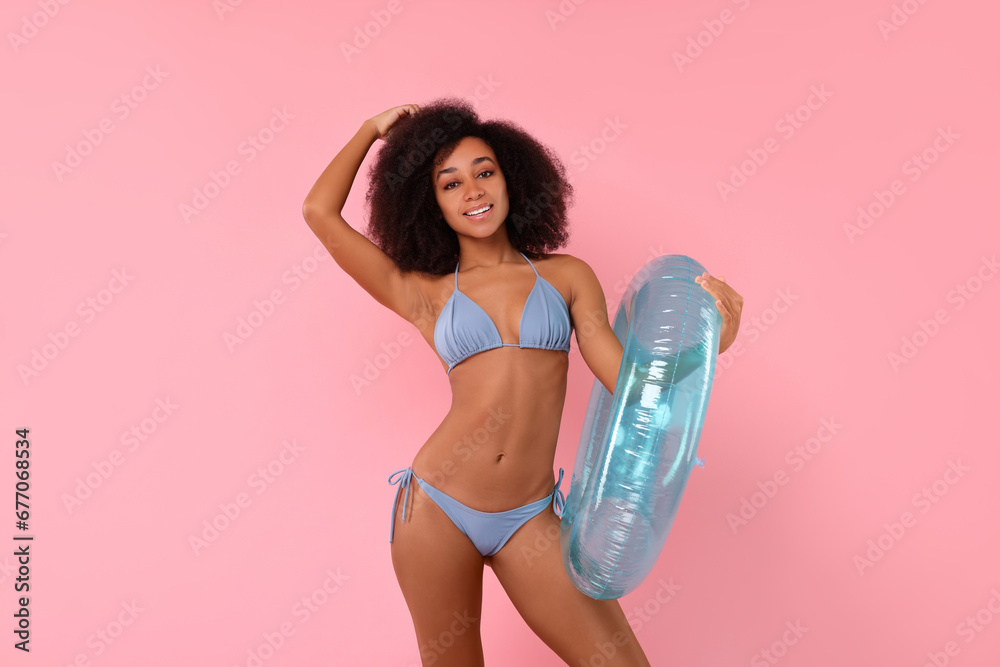 Beautiful woman in stylish bikini with inflatable ring on pink background Beautiful woman in stylish bikini with inflatable ring on pink background