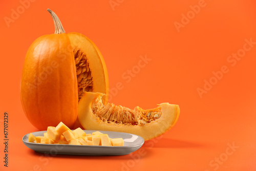 Fototapeta Naklejka Na Ścianę i Meble -  Cut fresh ripe pumpkin on orange background, space for text