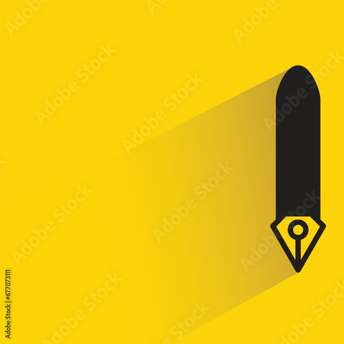 fountain pen with shadow on yellow background