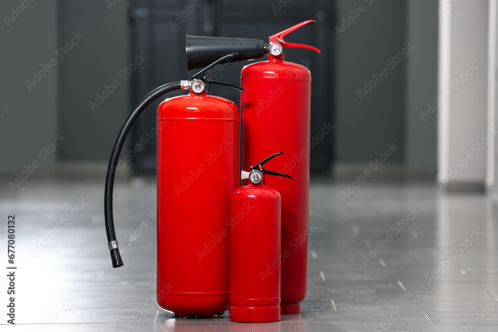 Three new red fire extinguishers in hall Three new red fire extinguishers in hall