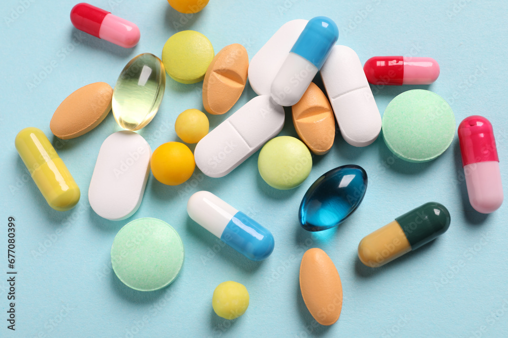 Many different pills on light blue background, flat lay Many different pills on light blue background, flat lay