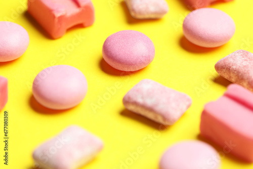 Pink bubble gums on yellow background, closeup
