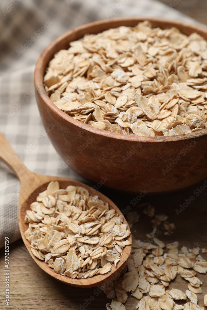 Bowl and spoon with oatmeal on wooden table, closeup Bowl and spoon with oatmeal on wooden table, closeup