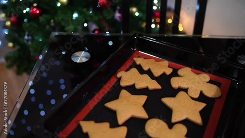 Figured Christmas cookies lie on a baking sheet on the table near the Christmas tree photo
