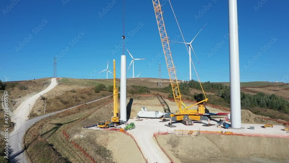 Aerial view of wind turbine under construction.
Green energy transition concept. Drone view in a sunny day in farm landscape. Sustainable growth.