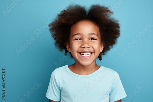 Confident Young Girl with Curly Hair Against Blue Background