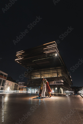 Modern City library De Krook building lit up with yellow and white lights during midnight in the centre of Ghent, Belgium. Flanders region photo