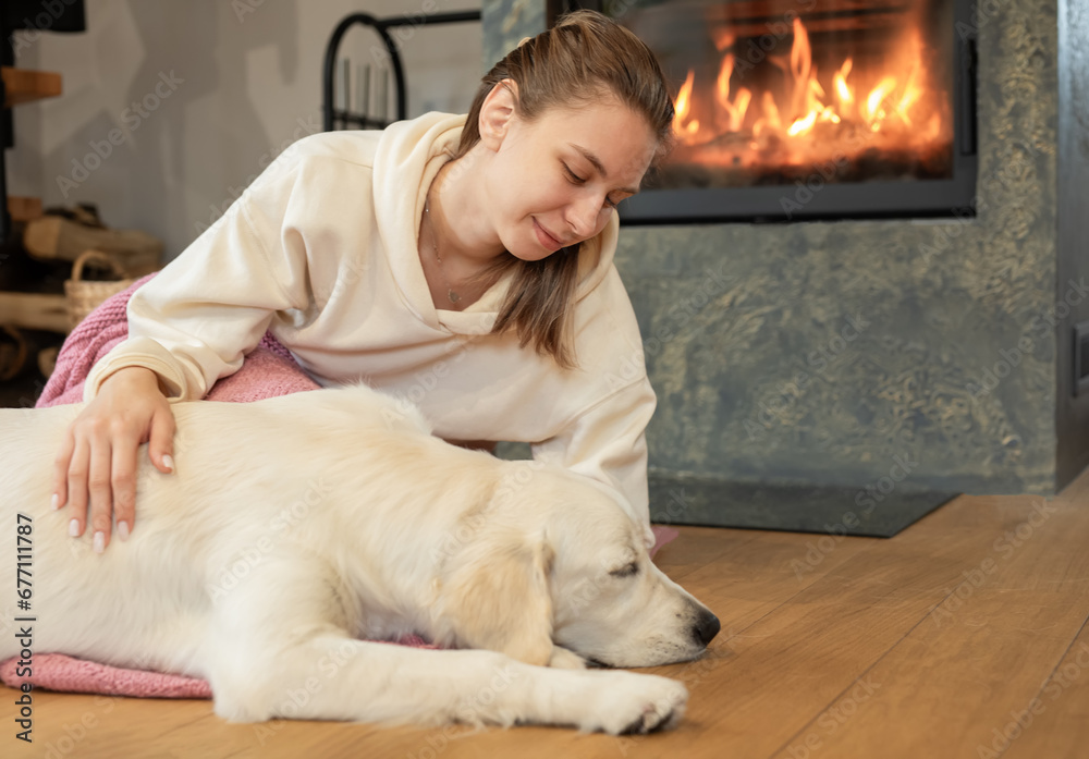 Woman sitting with dog near fireplace Woman sitting with dog near fireplace